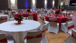 Venue with circular tables decorated in red and white Christmas colors