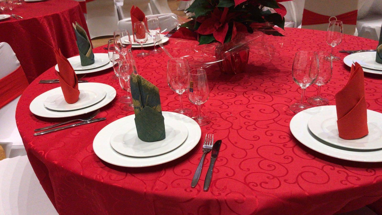 round table decorated in red with white plates and clear glasses